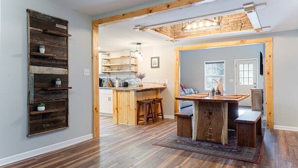 Cocina amplia con armarios de madera, una isla central y taburetes de bar.