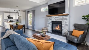 A modern living room with a stone fireplace, a flat-screen TV, and a comfortable seating area. - Modern Westside Retreat | 5 Min to Blue Ridge Parkway | 15 Min to Biltmore & Downtown Asheville (Fairview)