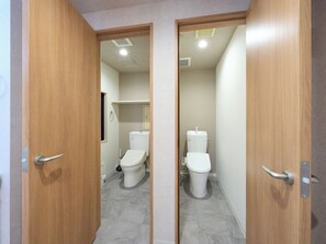 A bathroom with two toilets, a sink, and a mirror. - Retrospect Stay Kannai (Yokohama)