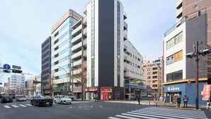 A multi-story building with a modern architectural design, featuring a prominent vertical element and a series of balconies.
