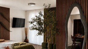 A modern bedroom with a bed, a large mirror, a potted plant, and a TV. - Hollywood Luxury Gem - 3 king beds - pool - gym - near ocean (Hollywood)