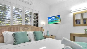 Une chambre d’hôtel comprenant un lit, une télévision, une fenêtre et une salle de bain.