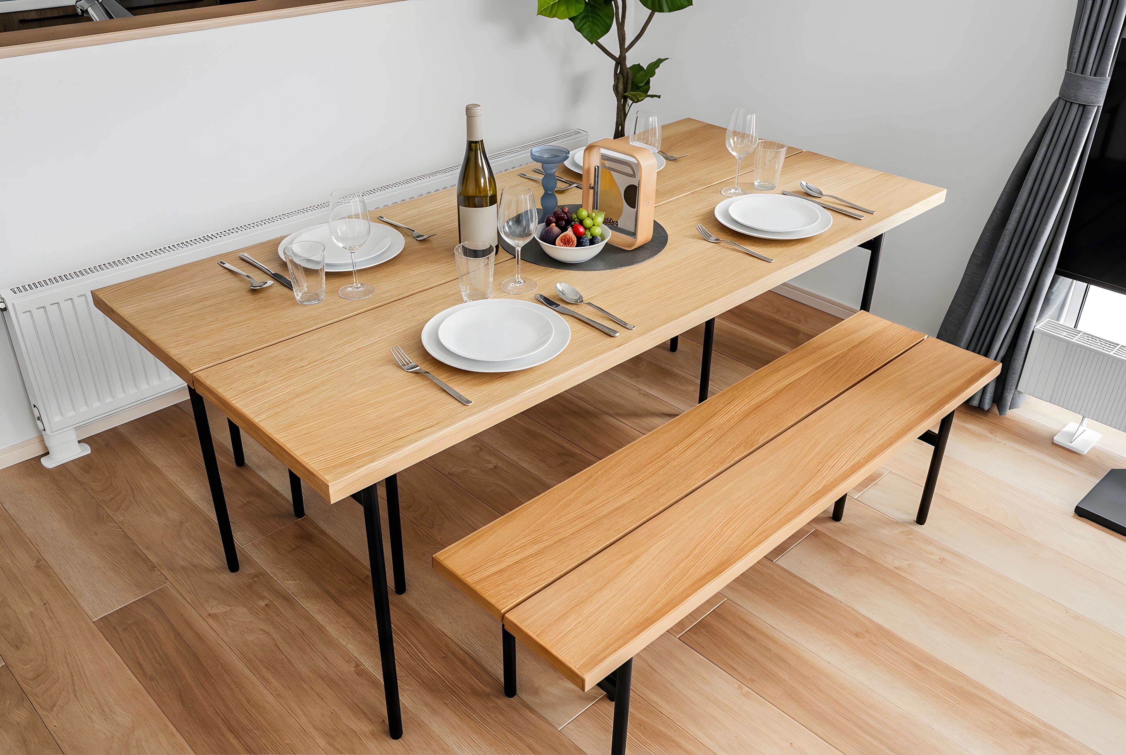 Una mesa de comedor dispuesta con platos, cubiertos, vasos y una botella de vino.