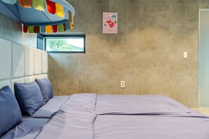 Un dormitorio moderno con cama, almohadas, cabecero, ventana y una obra de arte colgada en la pared.