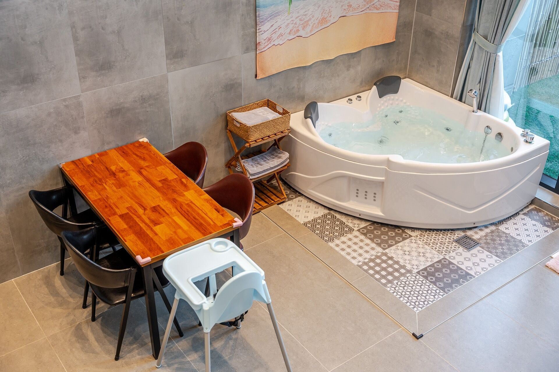 A bathroom with a wooden table, chairs, a bathtub, and a patterned floor.