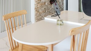 A small round table with a white surface, two wooden chairs, and a small glass container with a pen on it. - Gangneung Stay108 (Gangneung)