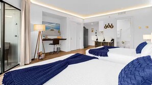 Une chambre d’hôtel avec deux lits, un bureau, une chaise, une lampe et une vue sur la mer.