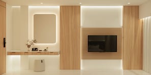 A modern bathroom with a wooden vanity, a large mirror, and a mounted TV.