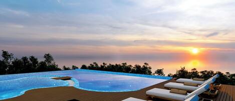 Een buitenzwembad, parasols voor strand/zwembad