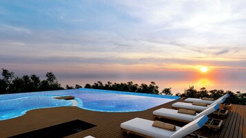 Una piscina al aire libre, sombrillas, sillones reclinables de piscina