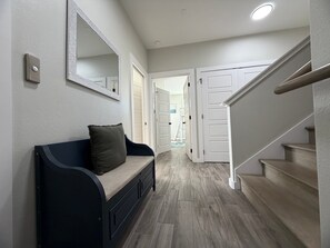 A hallway with a bench, a mirror, and a staircase. - Private Heated Pool, Golf Cart Included, Pet Friendly, Walk to the Beach (Port Aransas)