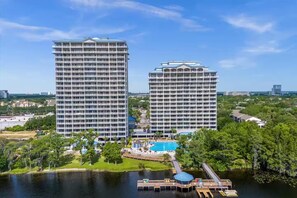 Twee hoge hotels met een zwembad en een steiger.