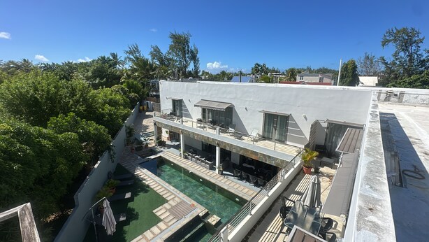 Ein Poolbereich auf dem Dach mit Liegestühlen und einem Schwimmbecken.