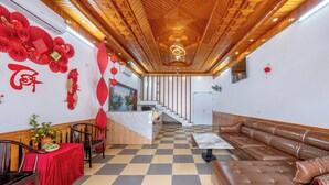 A hotel lobby with a checkered floor, a reception desk, a sofa, and a staircase. - Sao Phuong Nam Hotel (Ninh Binh)