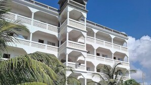 A multi-story hotel with balconies, a swimming pool, and palm trees. - Milalana residence & Hotel Malindi (Malindi)