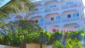 A multi-story building with balconies, a sign for Milalana Residence & Hotel, and lush greenery in the foreground. - Milalana residence & Hotel Malindi (Malindi)