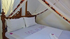 A bed with a canopy, white bedding, and a decorative pillow. - Milalana residence & Hotel Malindi (Malindi)