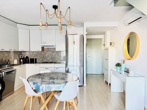 A modern kitchen with white cabinets, a granite backsplash, and a stainless steel refrigerator. - PORT CANIGO Duplex with private solarium (ROSES)