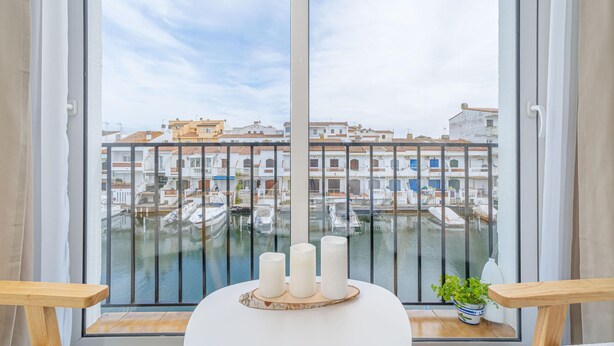 Un balcó amb vista a un port esportiu i edificis.