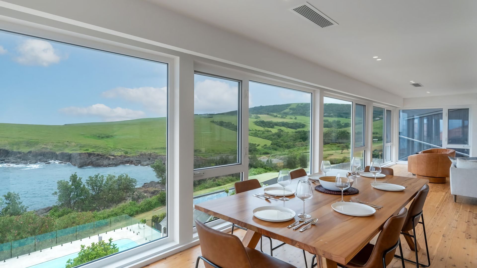 A dining area with a view of the sea and hills.