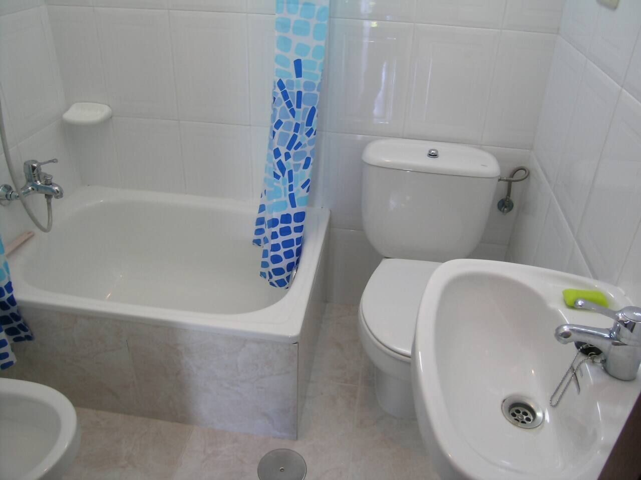 Een badkamer met een bad, toilet en wastafel.