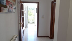 A hallway with a door leading to a balcony. - Ignacio C at the beach in Lariño (Lariño)