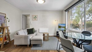 Una sala de estar moderna con un sofá, una mesa de vidrio y un televisor.