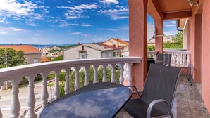 Ein Balkon mit Blick auf Häuser und einen klaren Himmel.