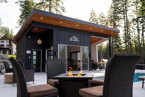A modern outdoor seating area with wicker furniture and a fire feature.