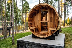 Een houten chalet met een gebogen buitenkant, gelegen in een bosrijke omgeving.