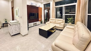Una sala de estar moderna con un sofá, una mesa de centro y un televisor montado en la pared.