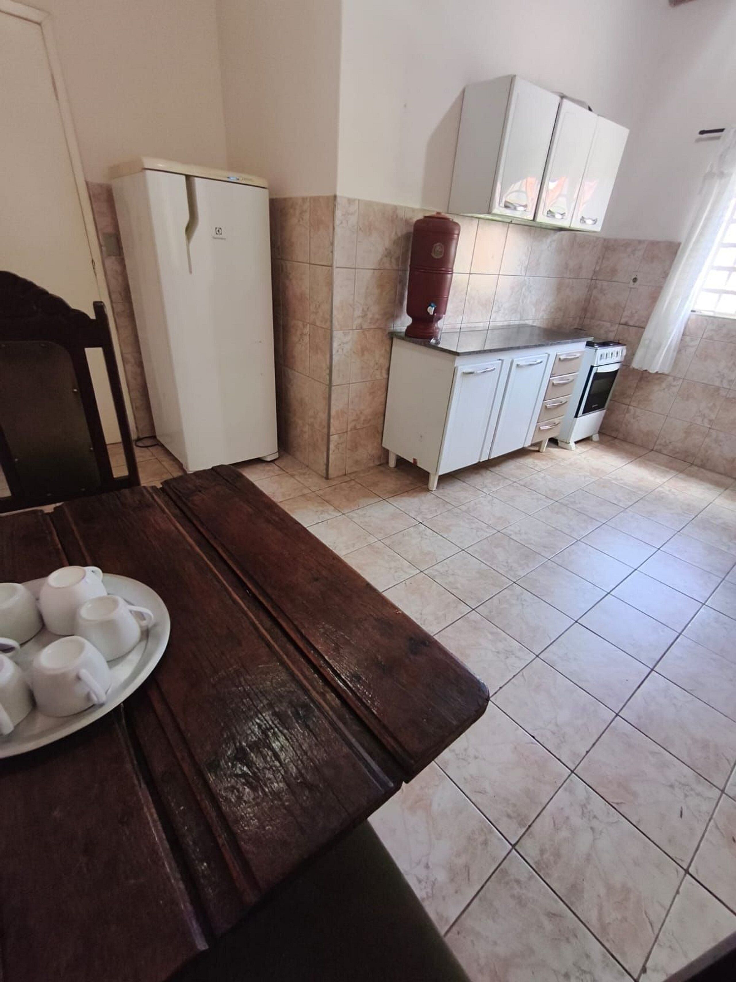 Una cocina con refrigerador, cafetera y estufa.