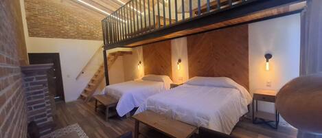 Un dormitorio estilo loft con dos camas, una escalera de madera y un comedor.