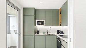 A compact kitchen with a microwave, sink, and modern appliances.