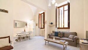 Un salón amplio con comedor, un sofá y una mesa de centro.