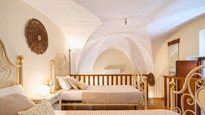 Un dormitorio con dos camas, una mesita de noche, una lámpara y un adorno de pared.