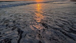 A beach with the sun setting over the water, creating a calm and reflective surface. - Rancho de 3 dormitorios en la Costa del Sol, La Paz. con aire acondicionado (El zapote)