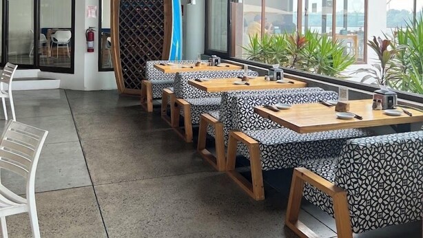A restaurant with long tables, chairs, and a large arched window. - Rancho de 3 dormitorios en la Costa del Sol, La Paz. con aire acondicionado (El zapote)