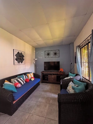 A living room with two sofas, a TV, and artwork on the walls.