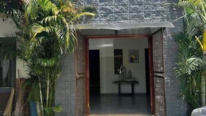 A house with a stone facade, a wooden door, and a small porch area. - Rancho de 3 dormitorios en la Costa del Sol, La Paz. con aire acondicionado (El zapote)
