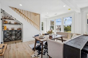 Ein modernes Interieur mit einer Treppe, einem Essbereich und großen Fenstern mit Blick.