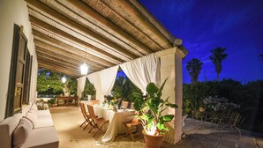 An outdoor patio with a covered dining area, a sofa, and potted plants. - Villa Nina - Luxury Villa with Pool in Salento, Zollino, Italy (Zollino)