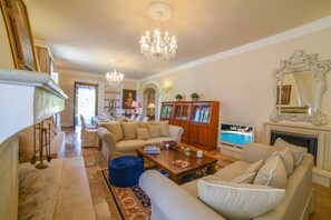A spacious living room with a chandelier, a television, and a fireplace. - Villa Nina - Luxury Villa with Pool in Salento, Zollino, Italy (Zollino)