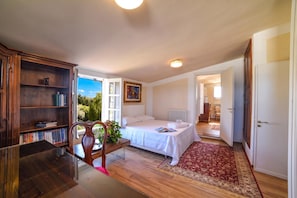 A bedroom with a bed, a desk, a chair, a bookshelf, and a view of the outdoors. - Villa Nina - Luxury Villa with Pool in Salento, Zollino, Italy (Zollino)