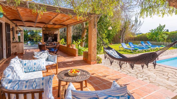 An outdoor patio with a covered seating area, a pool, and lounge chairs. - MIRABO - Villa with private pool and free WiFi (Manacor)