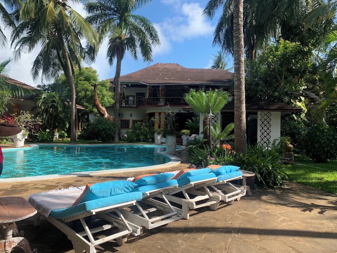A pool area with lounge chairs and a building in the background.