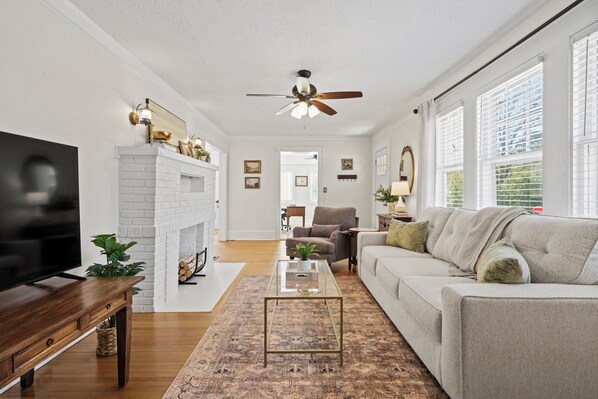 A living room with a fireplace, a sofa, a coffee table, and a television.