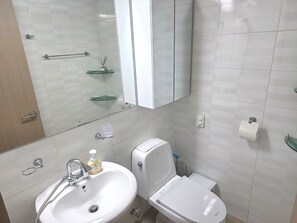 Een haardroger, handdoeken, zeep, toiletpapier