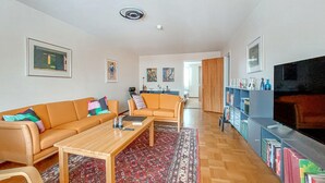 A living room with a sofa, coffee table, and a bookshelf.