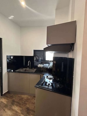 A compact kitchen with a sink, stove, and countertop.